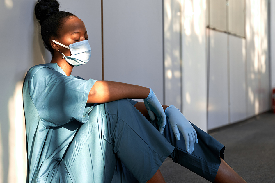 stressed nurse sitting with a wall